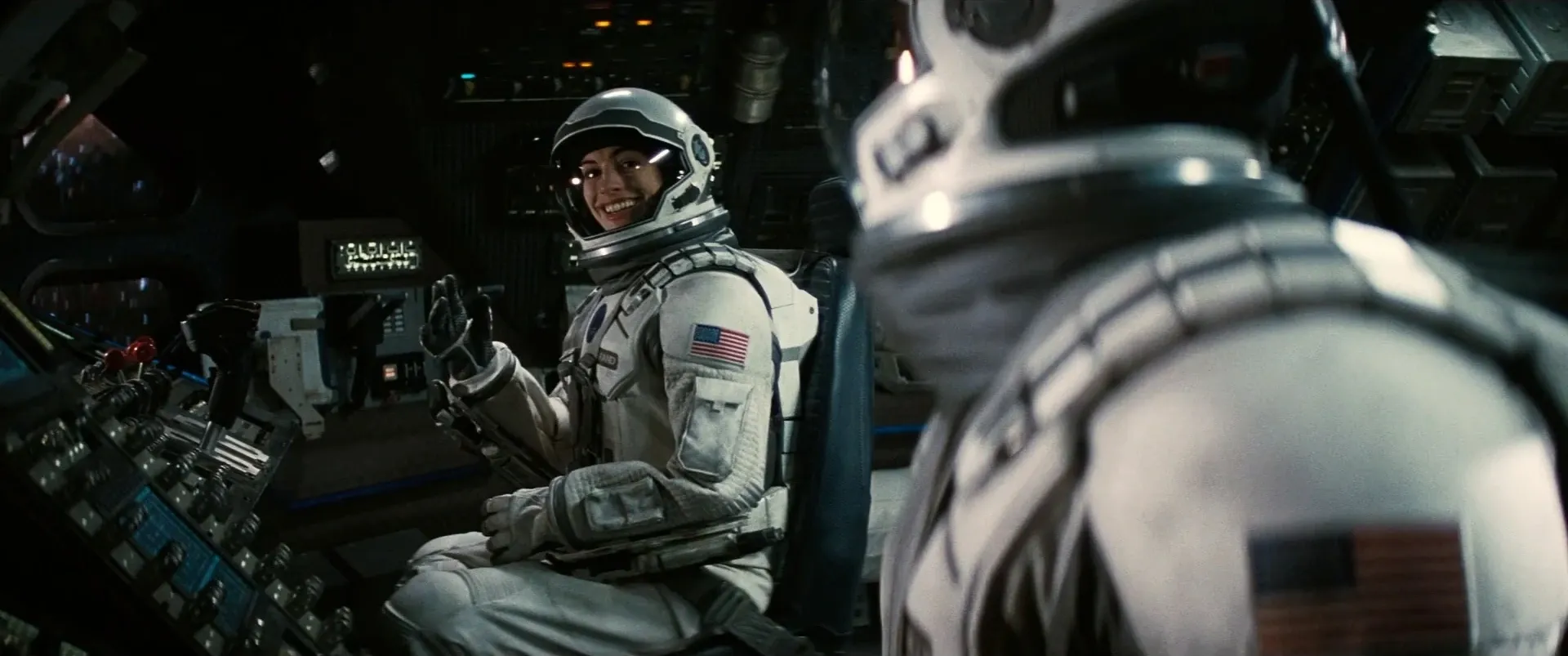 Interstellar cockpit interior lit almost entirely by the practical glow of the console, astronaut framed in large format (Interstellar, 2014)