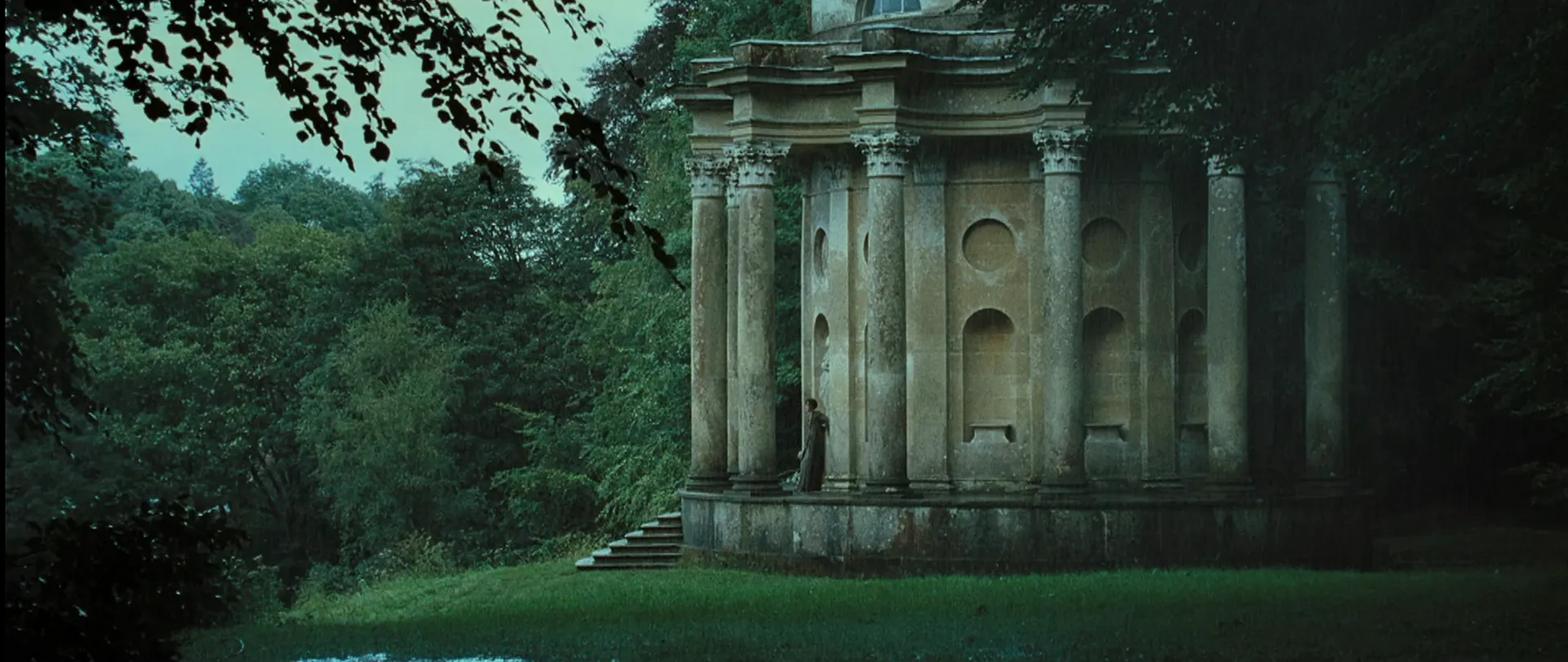 Pride & Prejudice (2005) — a lone figure dwarfed by a classical folly, the wide framing doing the emotional work no caption could.