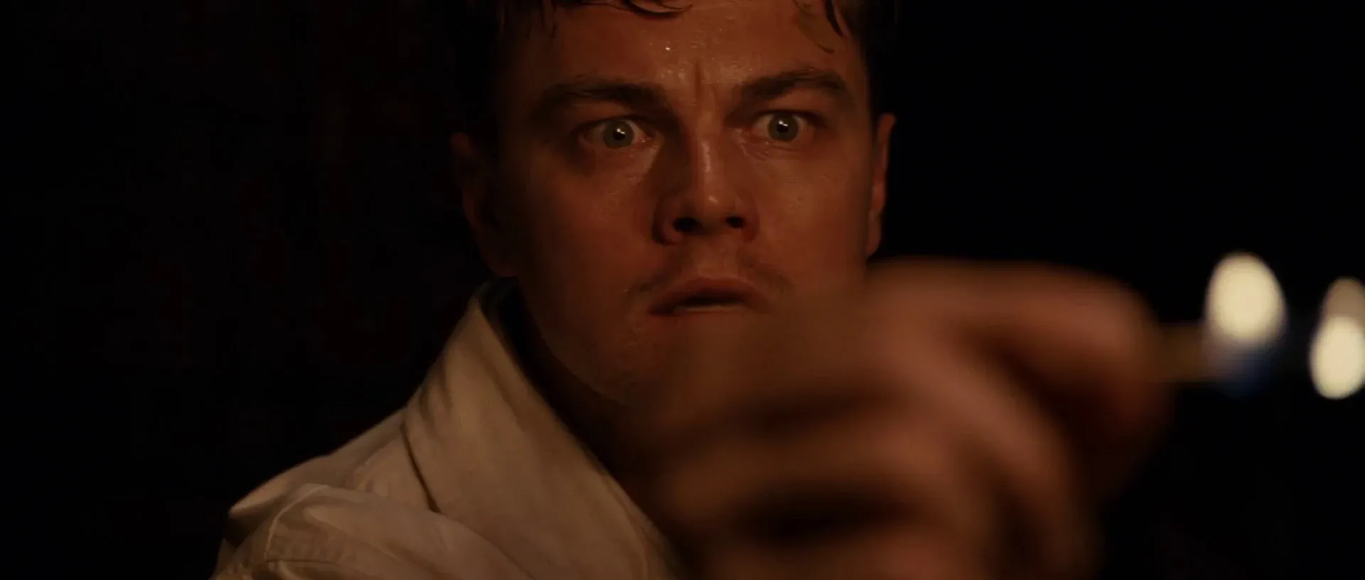 Shutter Island (2010) β a single warm source pools on the face while the surround falls to black