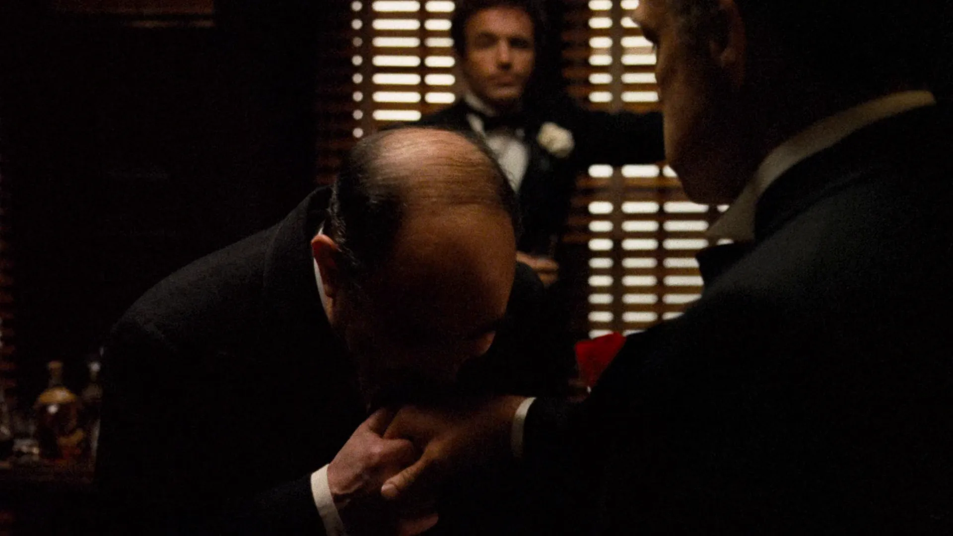 The Godfather (1972) — shuttered windows and practicals define the bright background while the foreground faces sit in shadow