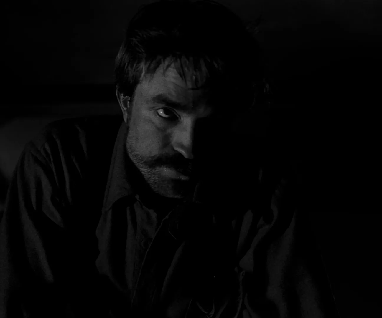 The Lighthouse (2019), DP Jarin Blaschke — a face emerging from near-total black, one catchlight left